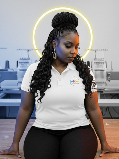 A woman wearing a white Performance Polo shirt with a logo in an embroidery studio.