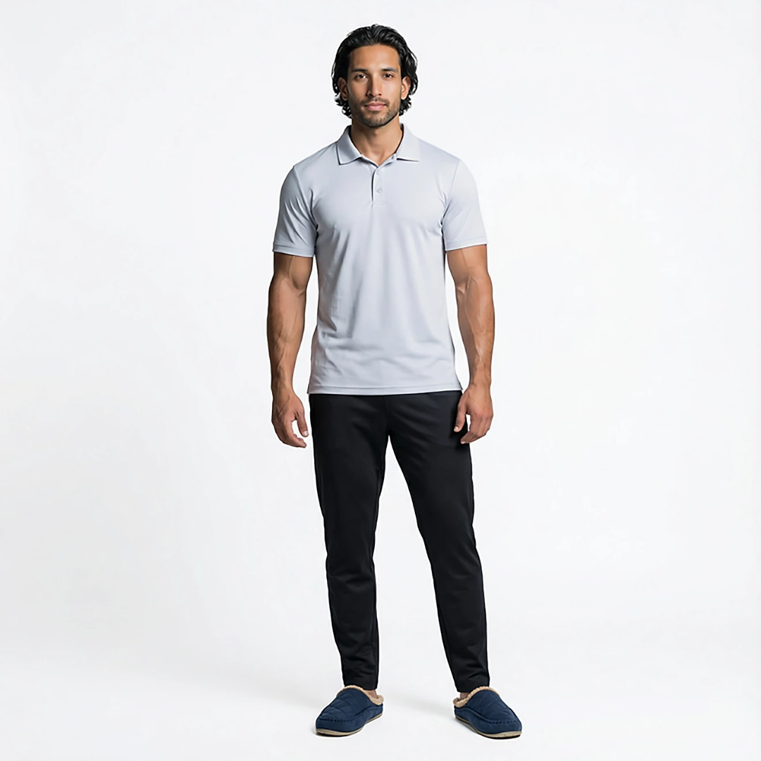 Man wearing a light gray polo shirt and black pants on a white background