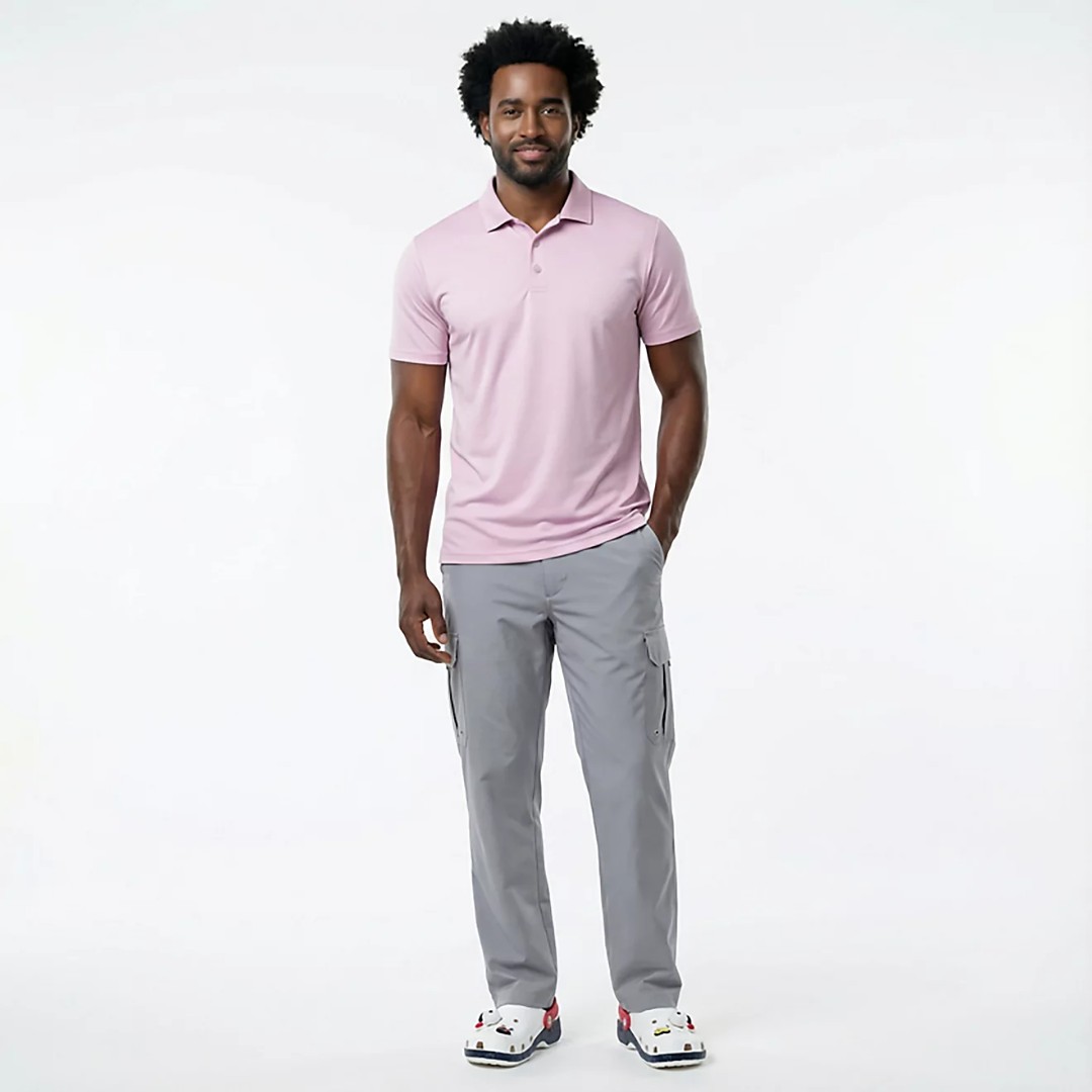 Man wearing a pink polo shirt and gray pants on a white background